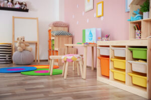 Photo of part of a room in a nursery, with brightly coloured furniture and wooden tables